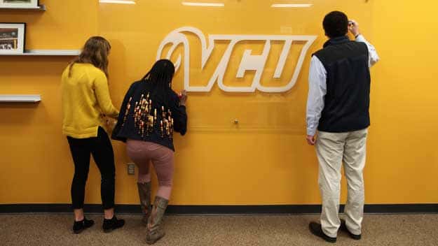 CSL students writing on clear board